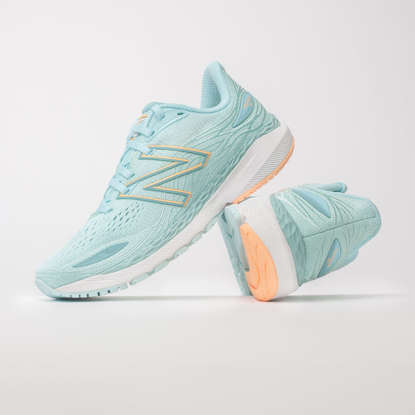 Left pair, side profile of light blue Fresh Foam 860v12, resting on the heel of the right pair with heel facing front