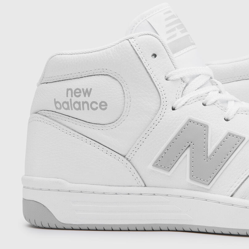 A detail image of pair of white hightop 480s on a grey background.