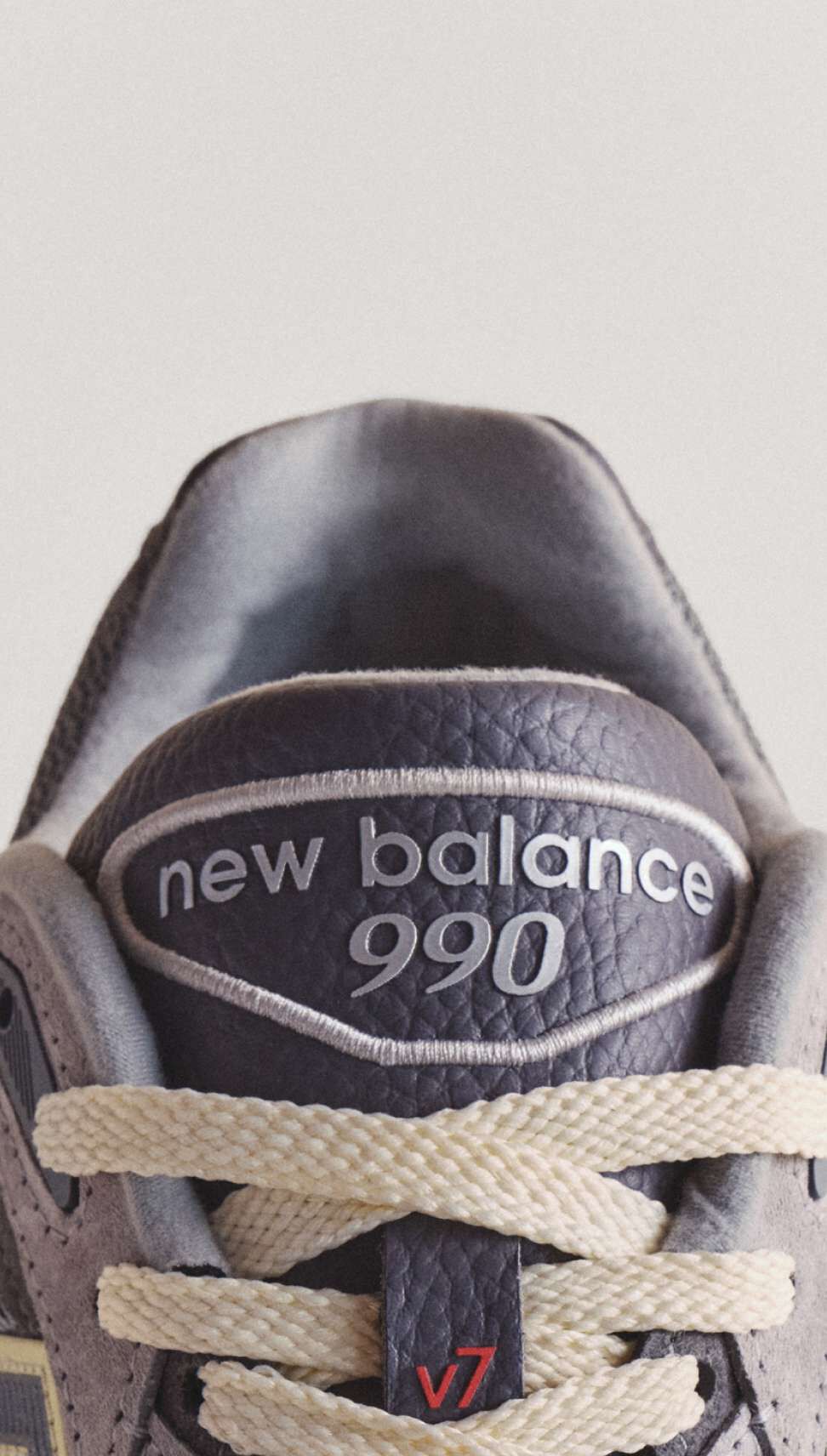 A close up visual of the tongue of the 990v7 sneaker, showing the product details.
