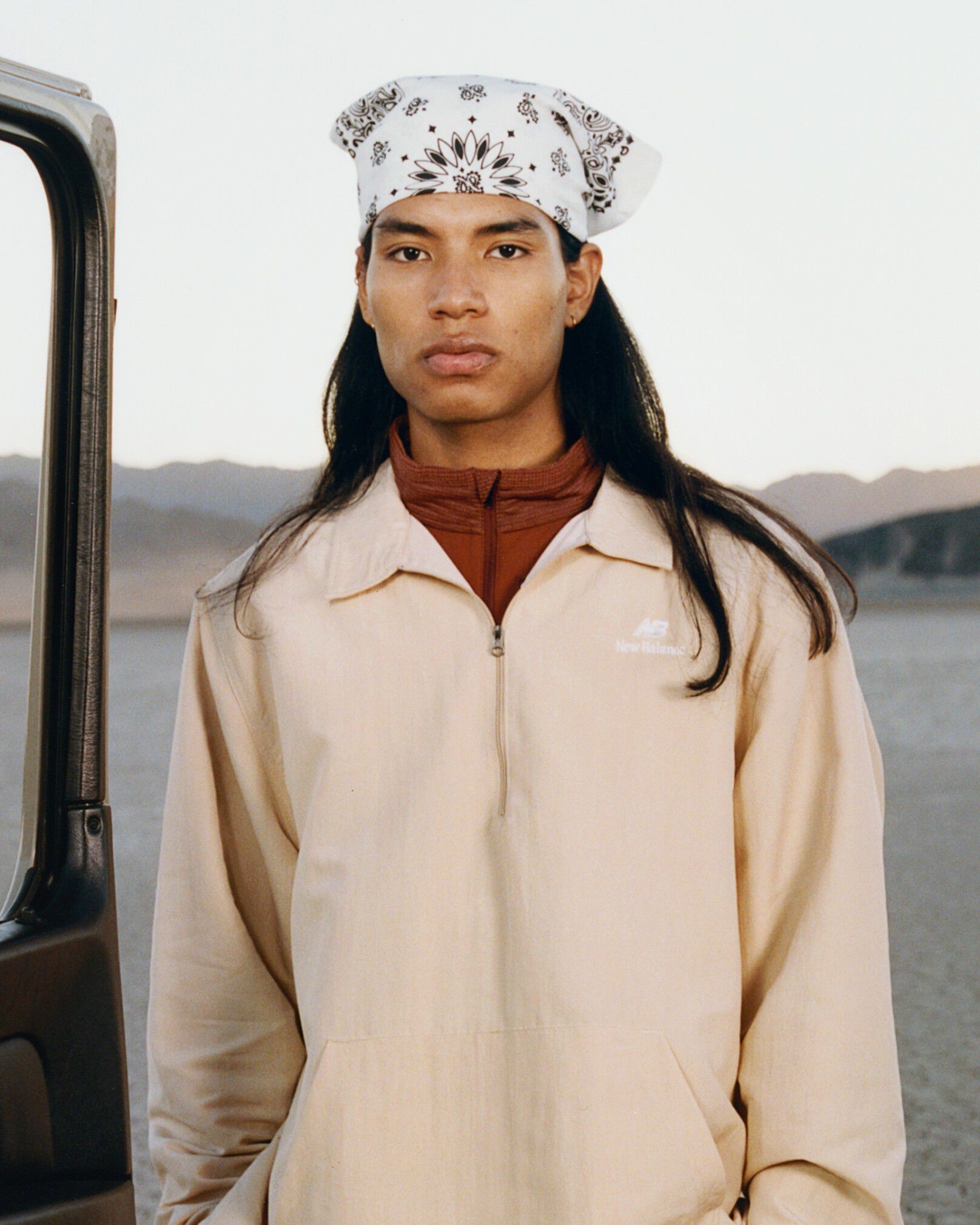 A man wearing New Balance standing in a desert environment. 