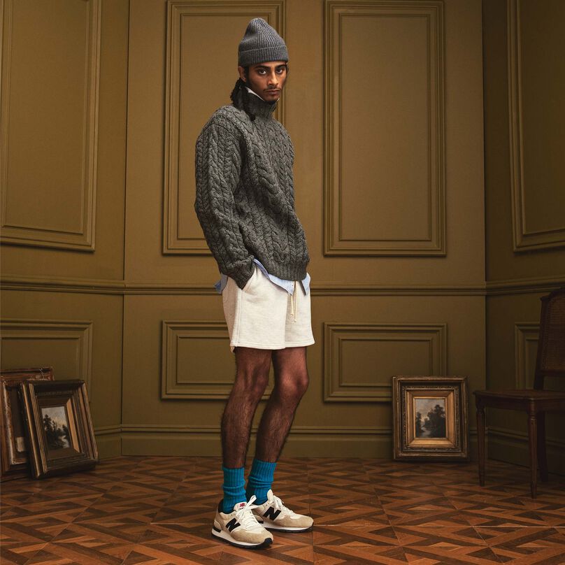 Man sitting on a wood bench in a beautiful indoor environment wearing MADE in USA apparel and footwear.